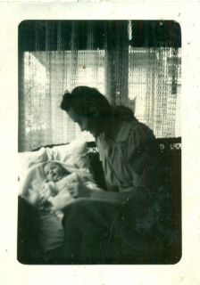 natural light photo mother in dark w/sun shining in window on baby 