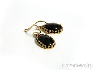  gold. These earrings are centered with 2 genuine oval cut Garnet