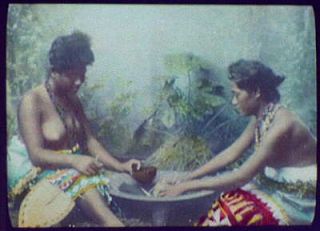 Photo Two bare breasted women around cooking pot